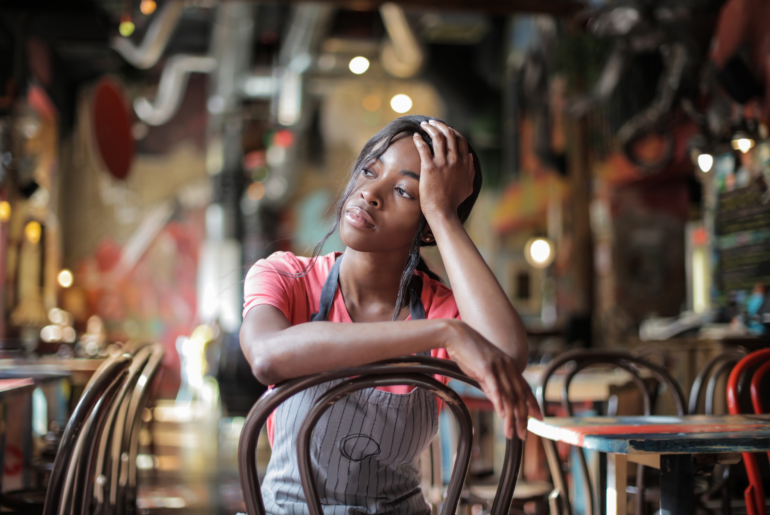 Food service worker sitting on a restaurant chair after hours.