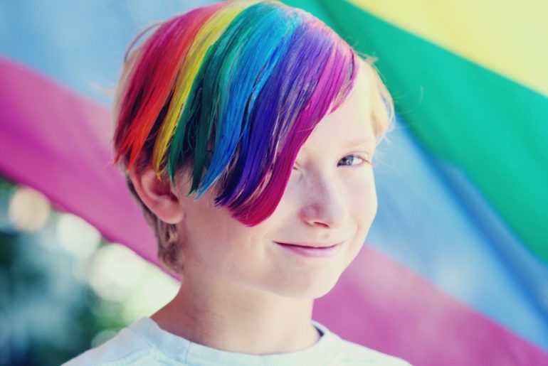 Celebrating LGBTQ+ Inclusiveness. Child with rainbow colored hair smiling.