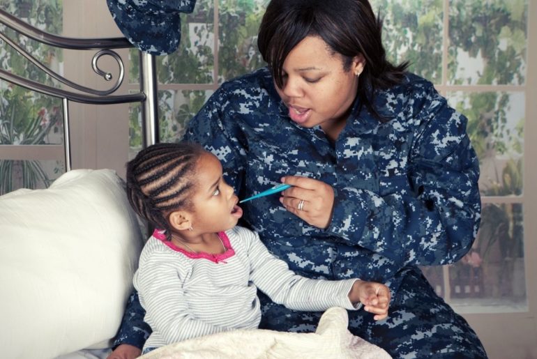 Mom taking daughter's temperature.