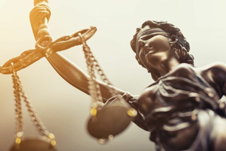A metal statue of Lady Justice holding a scale