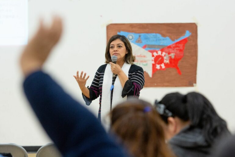 A teacher, school administrator, or parent representative speaks in front of a group of people